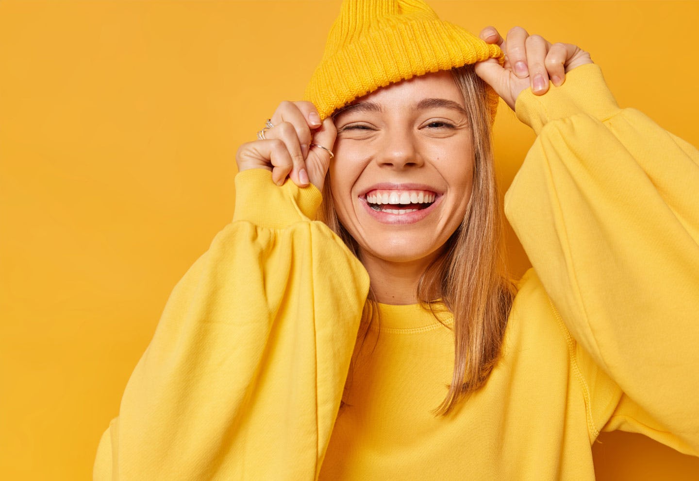 Woman in a sweater and beanie, smiling