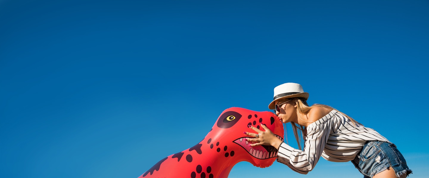 Girl kissing inflatable dinosaur