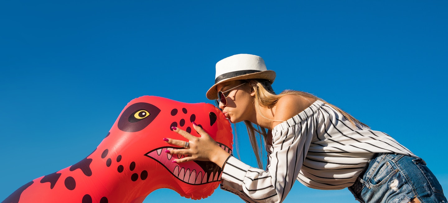Girl kissing inflatable dinosaur