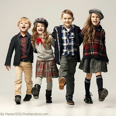 A group of young kids wearing preppy clothes and girls wearing skirts and thick boots socks with their boots