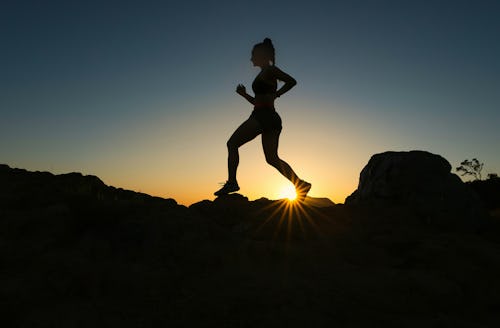 woman trail running on ridge