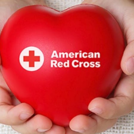 hands holding red cross heart